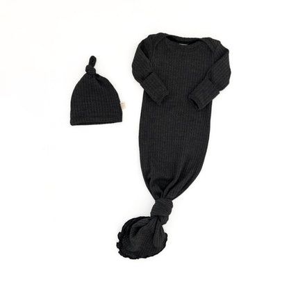 A black ribbed knit baby sleep sack with long sleeves and a tied knot