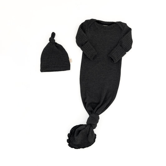 A black ribbed knit baby sleep sack with long sleeves and a tied knot