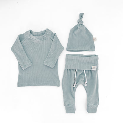 A three-piece baby clothing set in a mint blue color, including a long-sleeve ribbed top, matching pants with white drawstrings, and a knotted beanie hat