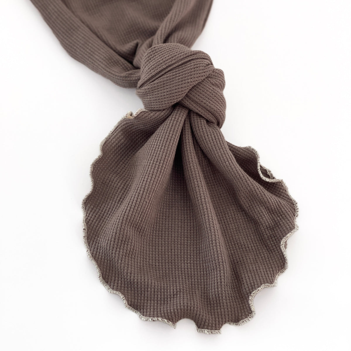 A close-up of a dark brown waffle-weave baby gown