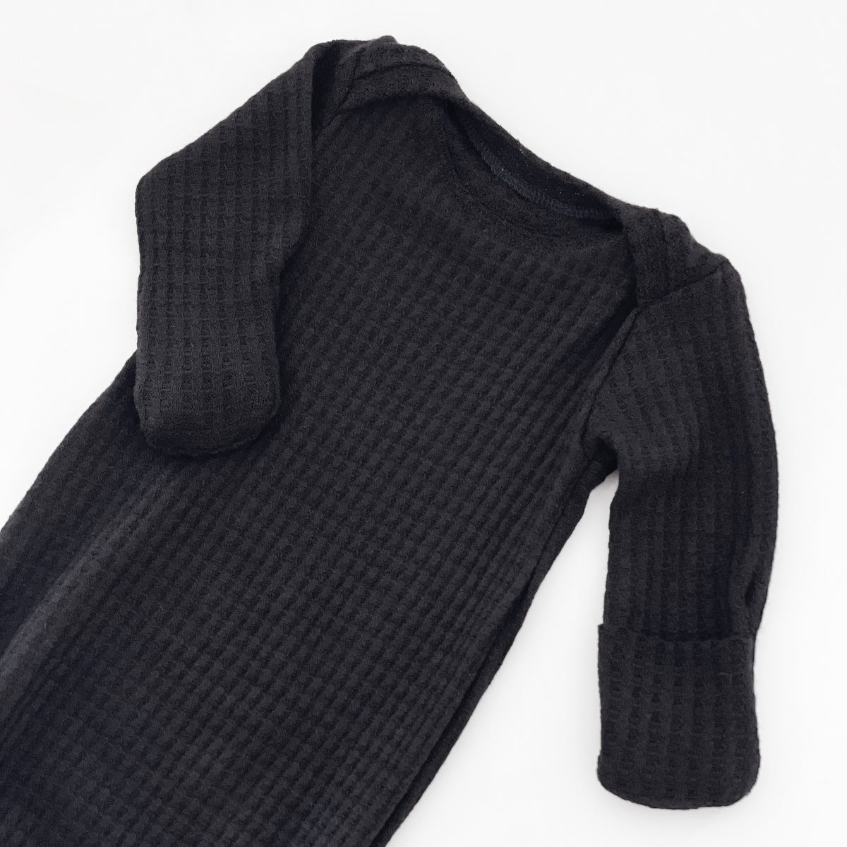 A black waffle-knit baby long-sleeve sleeper gown with fold over mitts