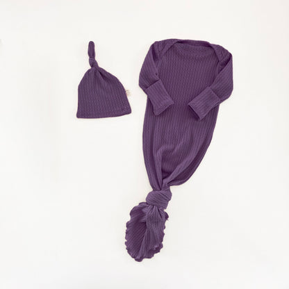 Two Sweet Cheeks plum purple waffle knit newborn knotted gown and matching baby hat on a white background.