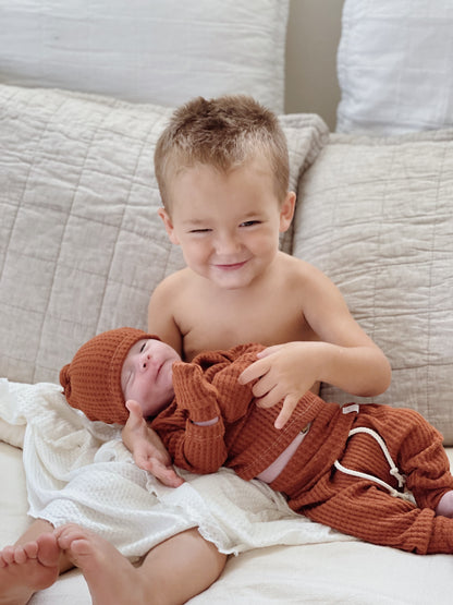Cozy unisex waffle knit baby set – rust brown long sleeve top, jogger pants, and hat for newborn boys and girls