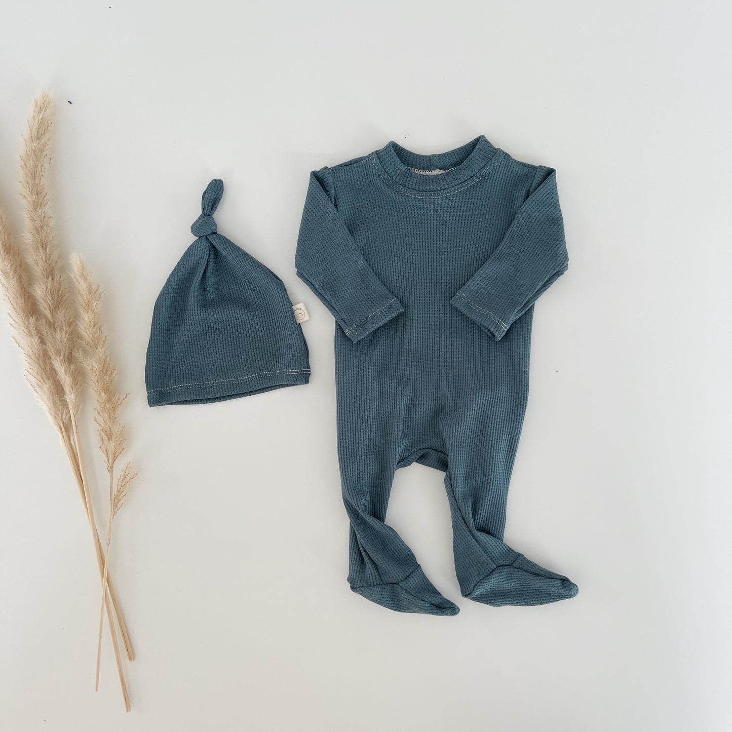 Thermal knit baby footie with convenient back flap, soft and stretchy newborn one-piece pajamas, baby boy infant outfit designed for easy diaper access and comfort.