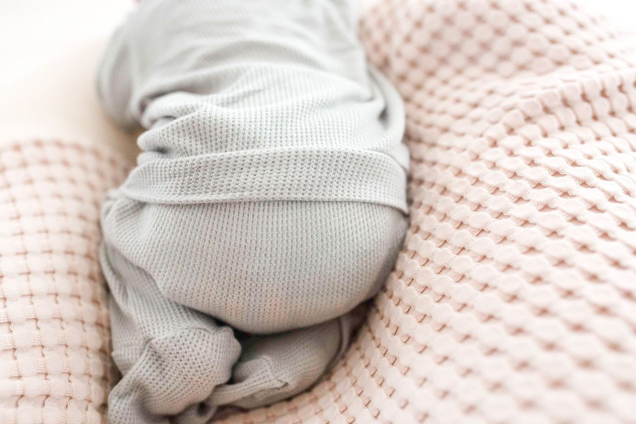 Newborn back flap footie onesie, soft waffle knit baby pajamas, baby boy infant outfit designed for comfortable overnight and daytime diaper changes.