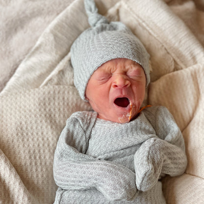 baby boy wearing soft waffle knit hat and gown in the hospital