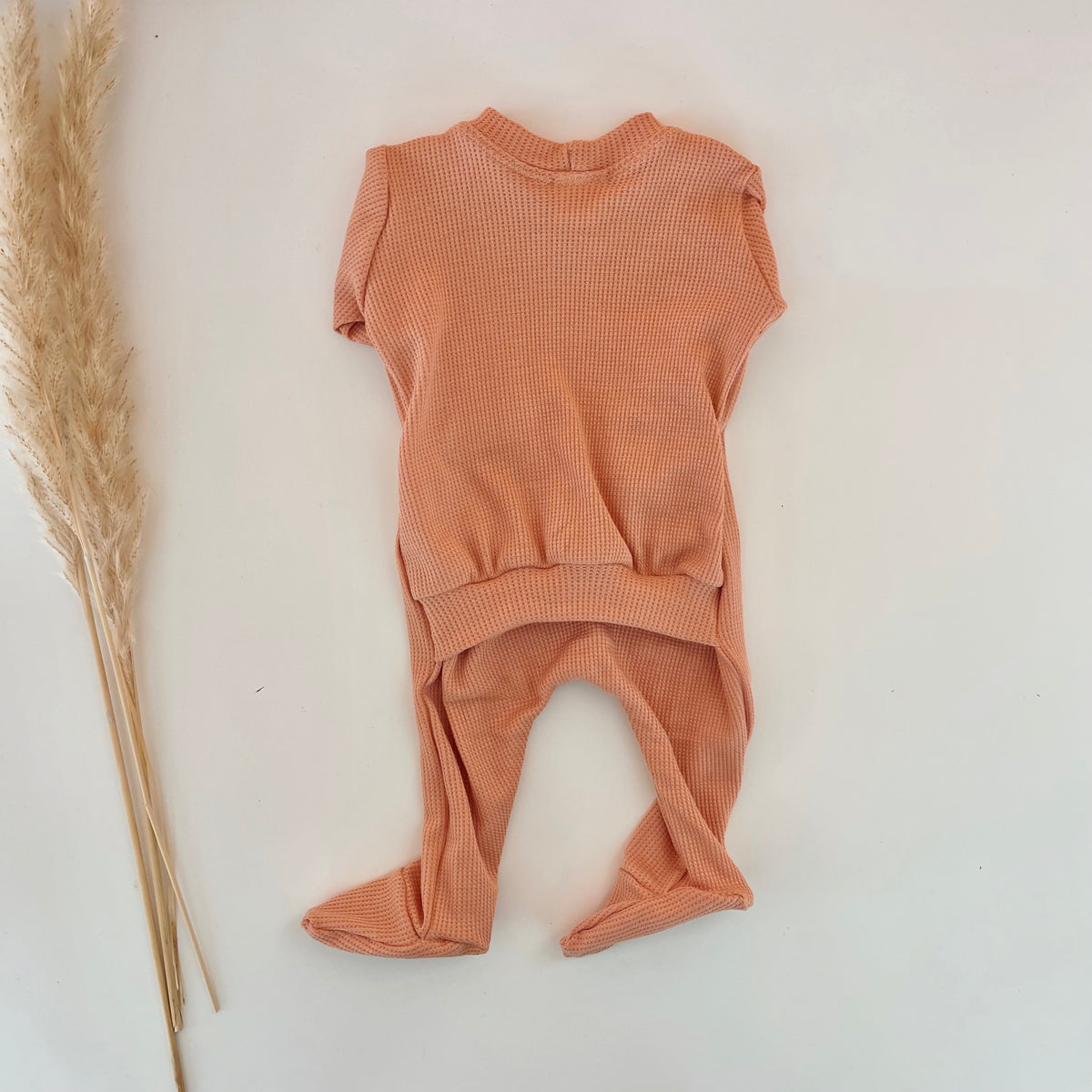 newborn girl footie pajamas in peachy pink