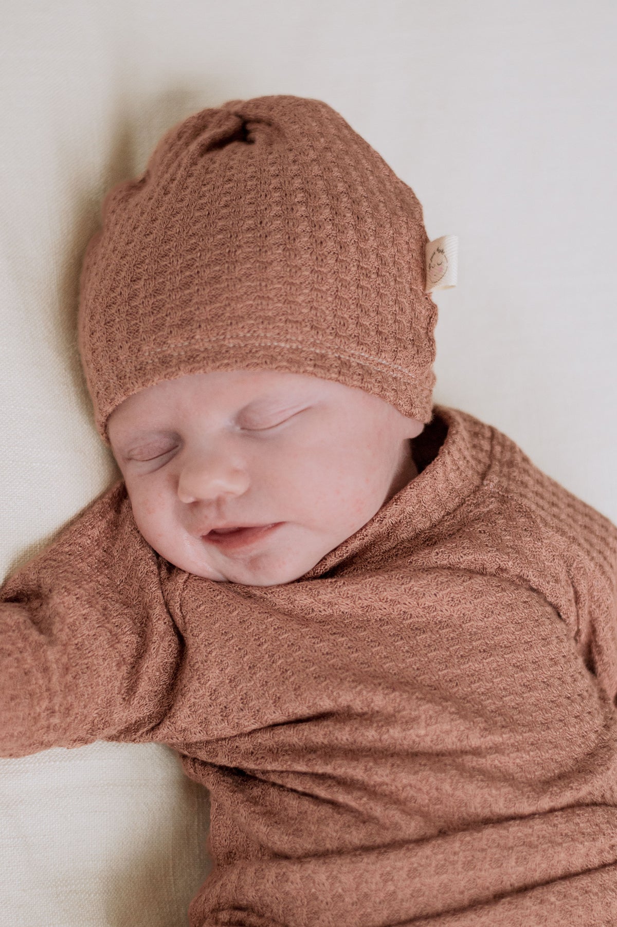muted tone baby girl wearing waffle knit hat and shirt