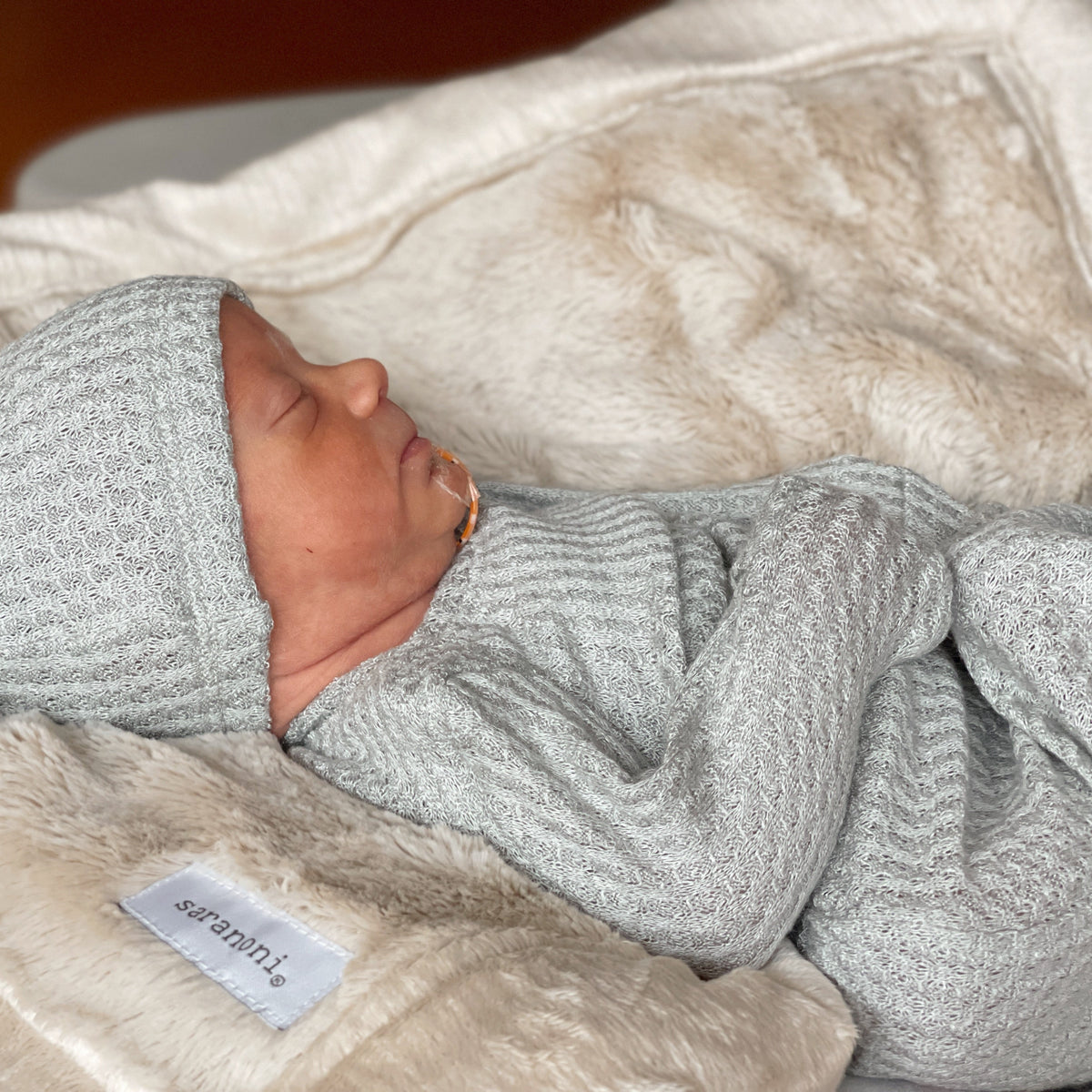nicu baby wearing mint color newborn gown and matching hat